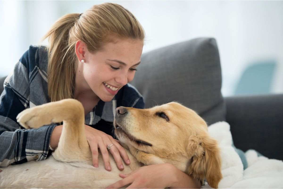 Ragazza con golden retriver abbraccio adozione