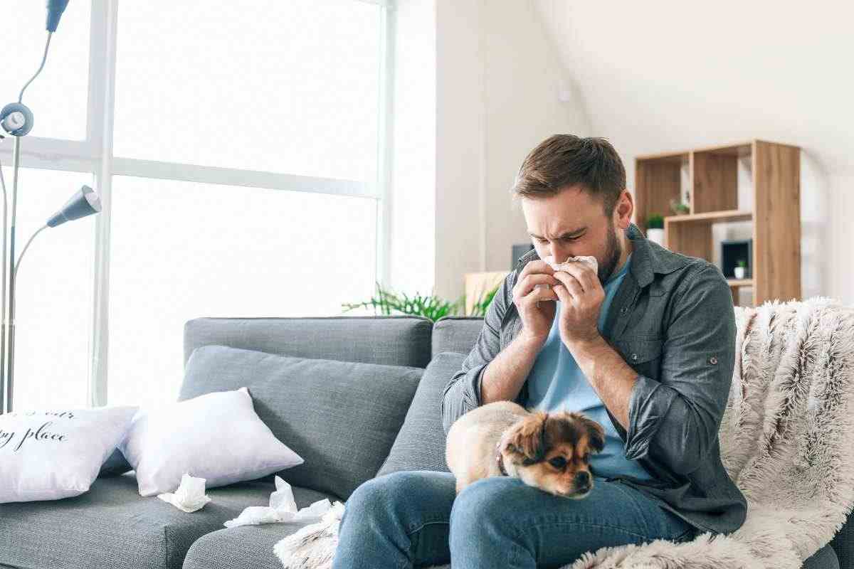 ragazzo starnutisce col cane in braccio